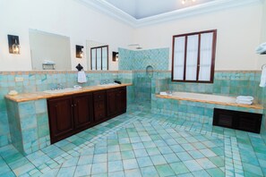 A bathroom with a large sink, a bathtub, and a shower.