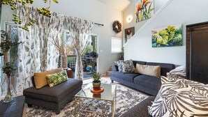 Un salon avec un canapé, une table basse et un tapis à motifs.