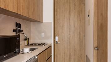 A modern kitchen with wooden cabinets, a built-in microwave, and a stainless steel sink.