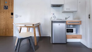 A compact kitchen with a refrigerator, microwave, and a coffee maker on the countertop. - Student Only Canvas The Old Fire Station Birmingham (Birmingham)