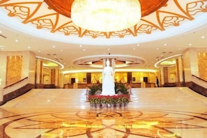 A spacious lobby with a central fountain, a chandelier, and a patterned floor. - Inner Mongolia Uiles Hotel (Hohhot)