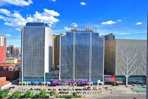 A cityscape with modern high-rise buildings, a parking area, and a clear sky. - Inner Mongolia Uiles Hotel (Hohhot)