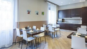 A modern kitchen with dark cabinets and a white countertop. - Hotiday Room Collection - Roma Barberini (Rome)