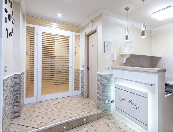 A reception area with a modern design, including a reception desk, a glass partition, and a door leading to a room. - Hotiday Room Collection - Roma Barberini (Rome)