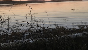 A calm lake with a clear sky at dusk.