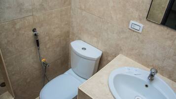 A bathroom with a toilet, sink, and shower.