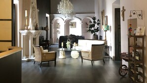 A spacious living room with a large chandelier, comfortable seating, and a wine rack. - Hotel Posada San Miguel (Jerez de García Salinas)