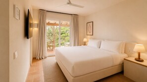 A hotel room with a bed, bedside lamps, a TV, and a view of the outdoors.