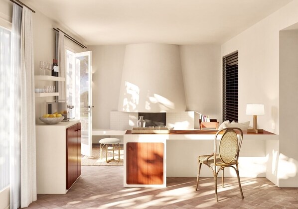 A modern kitchen with a central island, a dining area with a chair, and a window with blinds. - Finca Victoria Hotel & Spa (Begur)