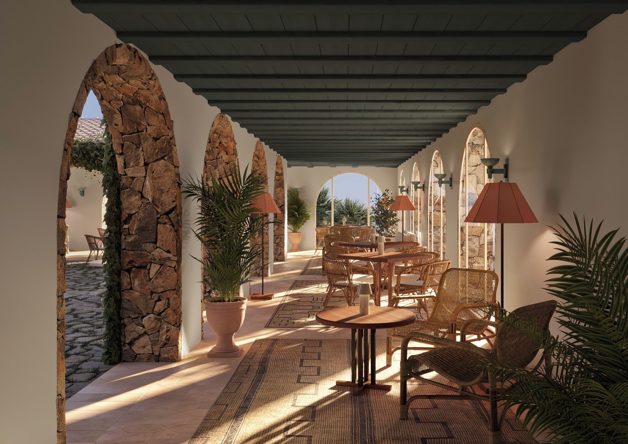 Un patio exterior con arcos de piedra, mobiliario de mimbre y plantas en macetas.