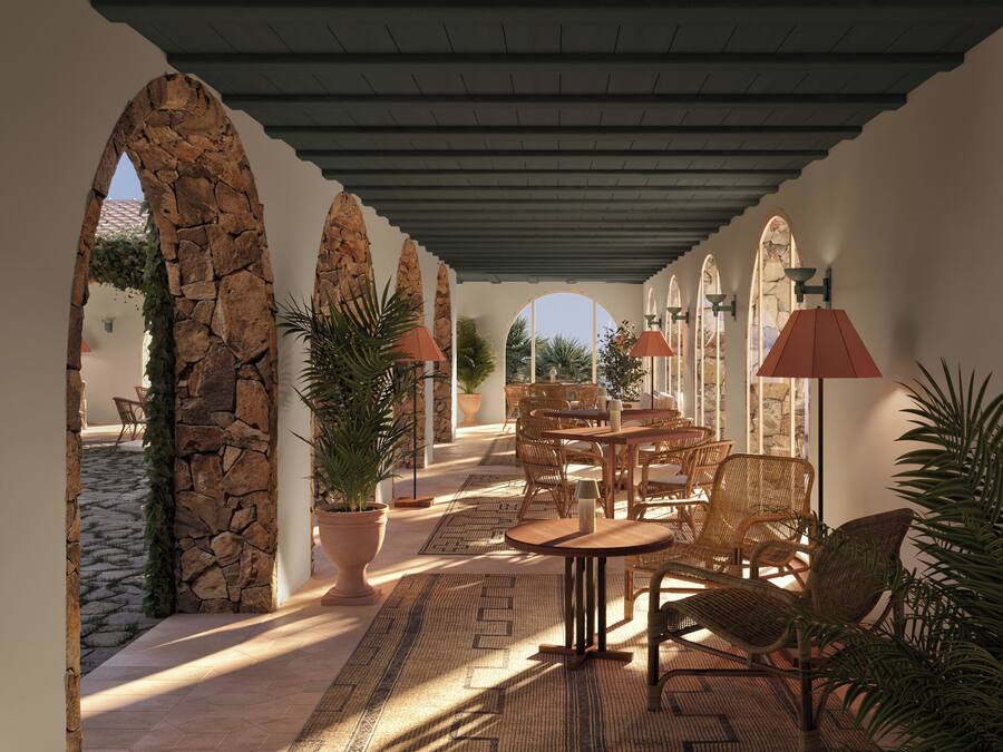 An outdoor patio with stone arches, wicker furniture, and potted plants.