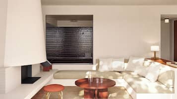 A modern living room with a sofa, a round coffee table, a red stool, a large floor lamp, and a window with blinds.