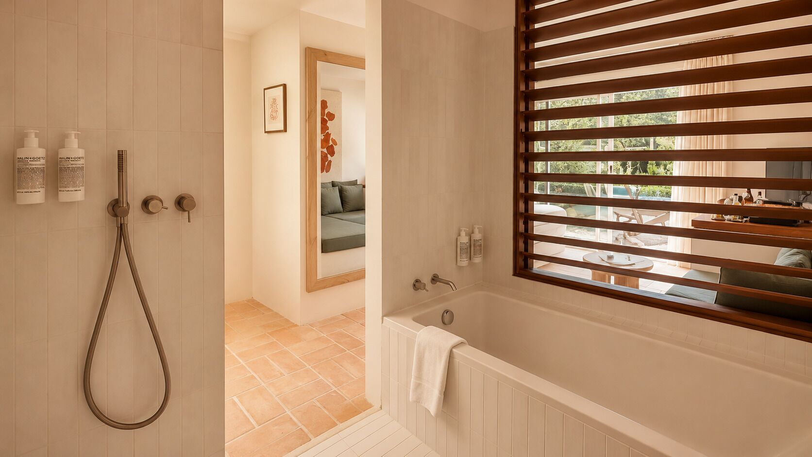 Un baño con bañera, ducha y persianas de madera.