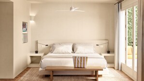A bedroom with a bed, bedside tables, a bench, a ceiling fan, and a large window. - Finca Victoria Hotel & Spa (Begur)