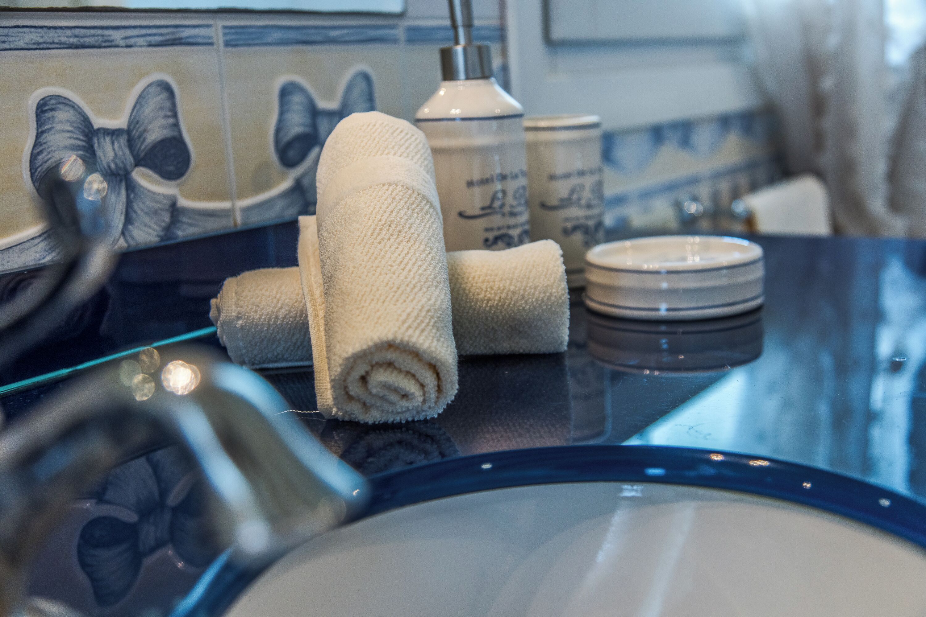 Une salle de bain avec un lavabo, une serviette et un flacon de savon pour les mains.