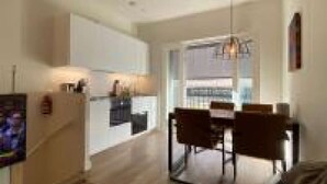A modern living room with a sofa and a coffee table, a dining area with a table and chairs, and a kitchen with a dining table and chairs. - Stylish House in Breda city center (Breda)