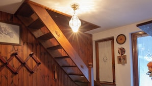Eine Holztreppe mit einer Holzhandläufe und einer Lampe darüber.