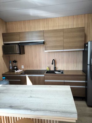 Frigorífico, microondas, utensilios de cocina y mesa de comedor