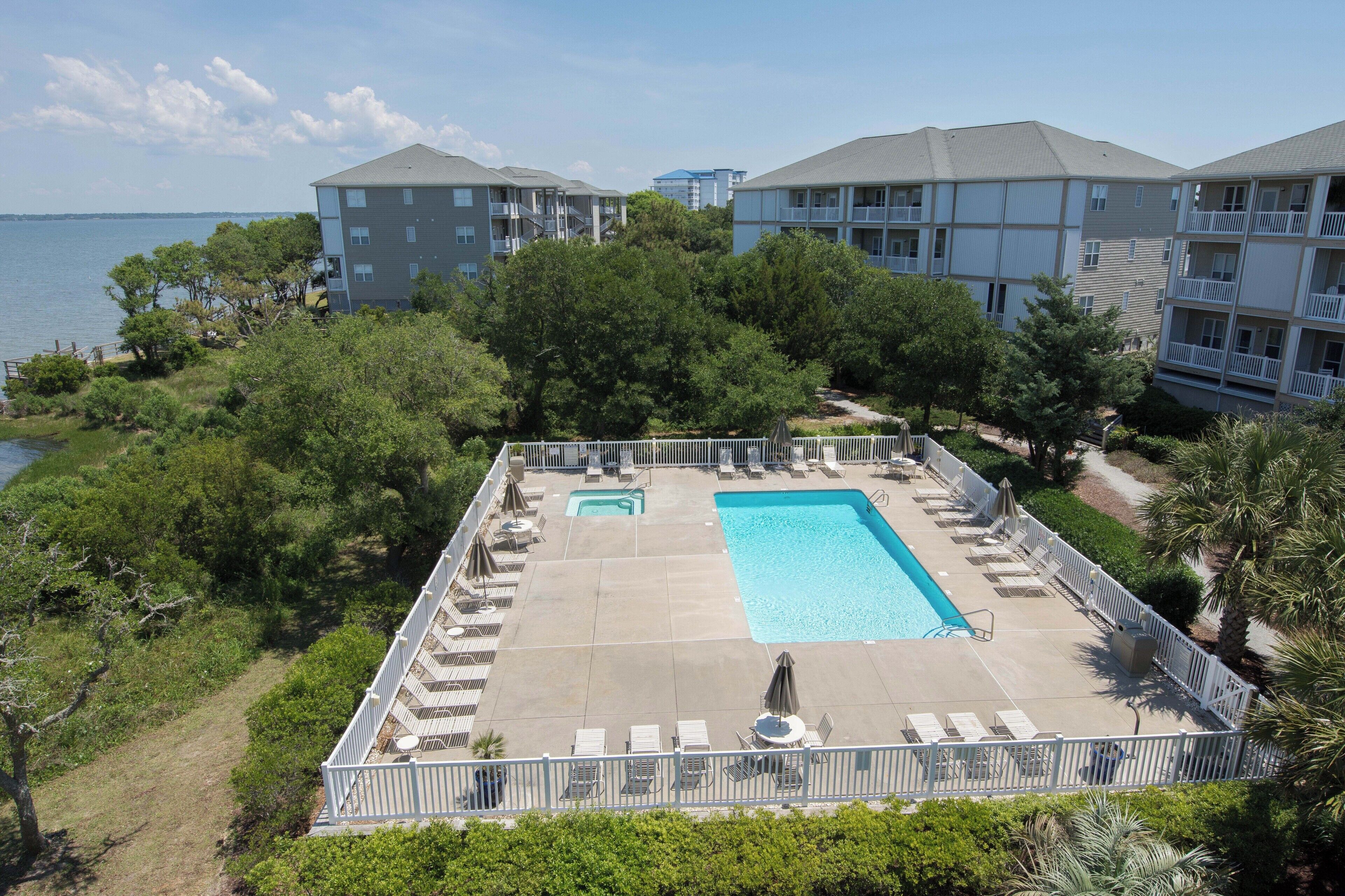 Une piscine avec des chaises longues et vue sur la mer.