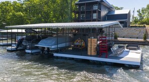 A houseboat with a covered deck, a wakeboard, and a sign that says 'Thriller.' - Hidden Valley Paradise (Glaze Township)