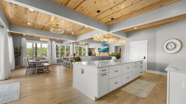 A spacious kitchen with a large island, wooden ceiling, and pendant lighting. - Hidden Valley Paradise (Glaze Township)