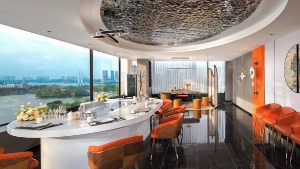 A modern kitchen with a central island, large windows, and a city view. - West Lake Garden Hotel (Huizhou)
