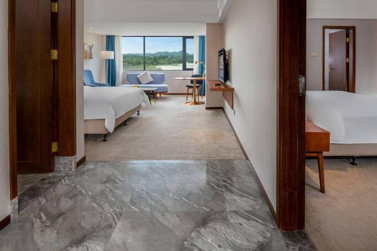Una habitación de hotel con cama, sofá, escritorio y televisión.