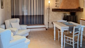 A living room with a sofa, a table, and a fireplace.