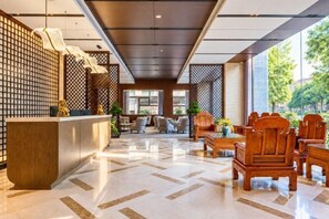 A hotel lobby with a reception desk, seating area, and large windows. - Rishengchang Hotel (Beijing South Railway Station) (Beijing)