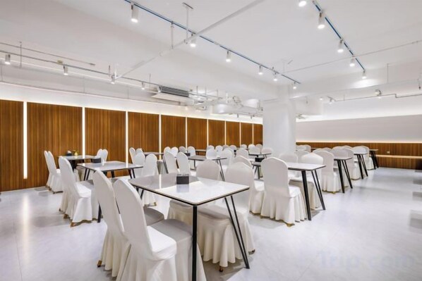 A conference room with multiple tables and chairs, equipped with projectors and a large screen. - Rishengchang Hotel (Beijing South Railway Station) (Beijing)