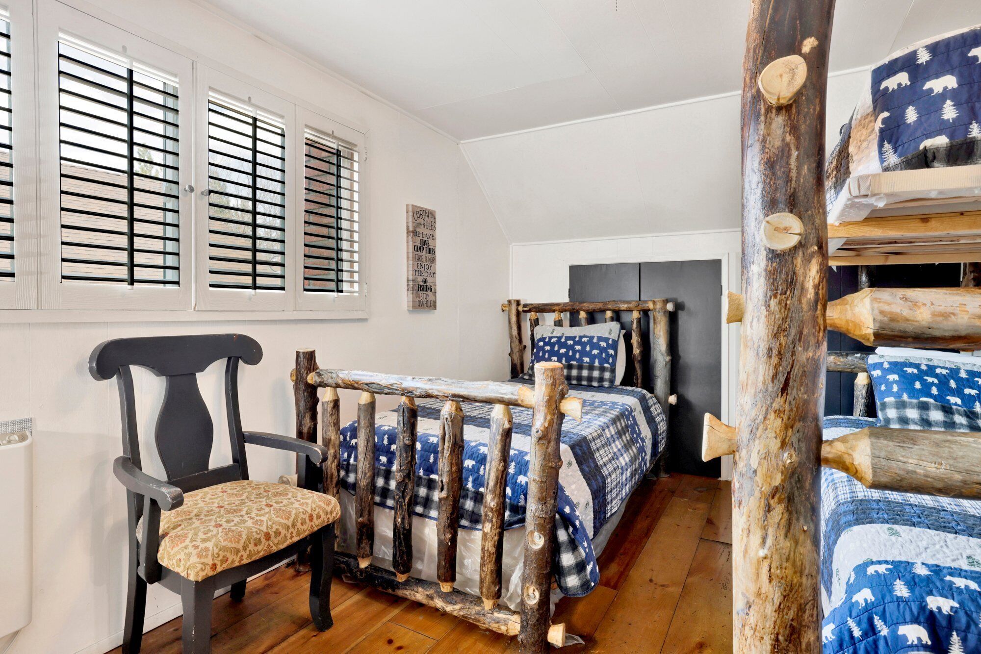 Una habitación acogedora con una cama, una silla y una estructura de madera rústica.
