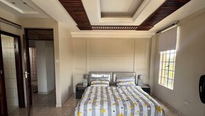 A bedroom with a bed, a window, and a door.