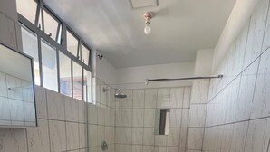 A bathroom with a toilet, bidet, and shower stall.
