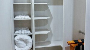 Un dressing avec plusieurs étagères et un banc en bois.
