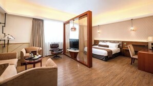 A hotel room with a bed, two armchairs, a desk, a television, and a mirror. - Zhengsheng Hotel (Guangzhou Baiyun Railway Station Xiaoping Subway Station) (Guangzhou)