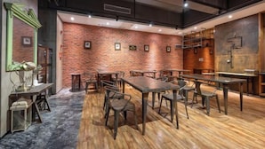 A restaurant with brick walls, wooden tables, and metal chairs. - Zhengsheng Hotel (Guangzhou Baiyun Railway Station Xiaoping Subway Station) (Guangzhou)