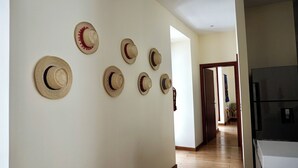 A hallway with a series of hats on the wall and a refrigerator in the foreground. - La Ronda 431 - Apt. #104 (Quito)
