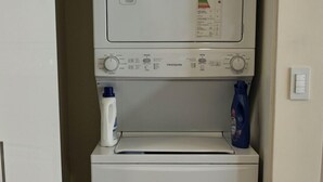 Eine kompakte Waschmaschine und ein Trockner in einem kleinen Hauswirtschaftsraum.