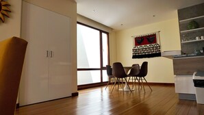Ein moderner Essbereich mit Holzboden, einem weißen Schrank und einem Esstisch mit vier Stühlen.