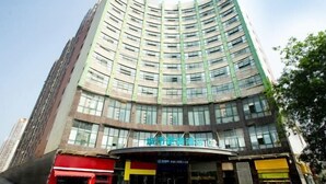 A multi-story hotel with a curved facade, large windows, and a prominent entrance with signage. - City Comfort Inn(Wuhan Jiangxia Branch) (Wuhan)