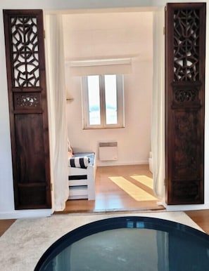 Una stanza con piscina, un letto, una finestra e una porta con decorazioni elaborate.