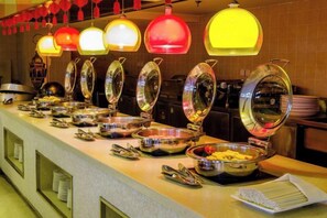 A buffet setup with multiple serving stations and overhead lighting. - Spring Downtown Hotel (Chengdu)