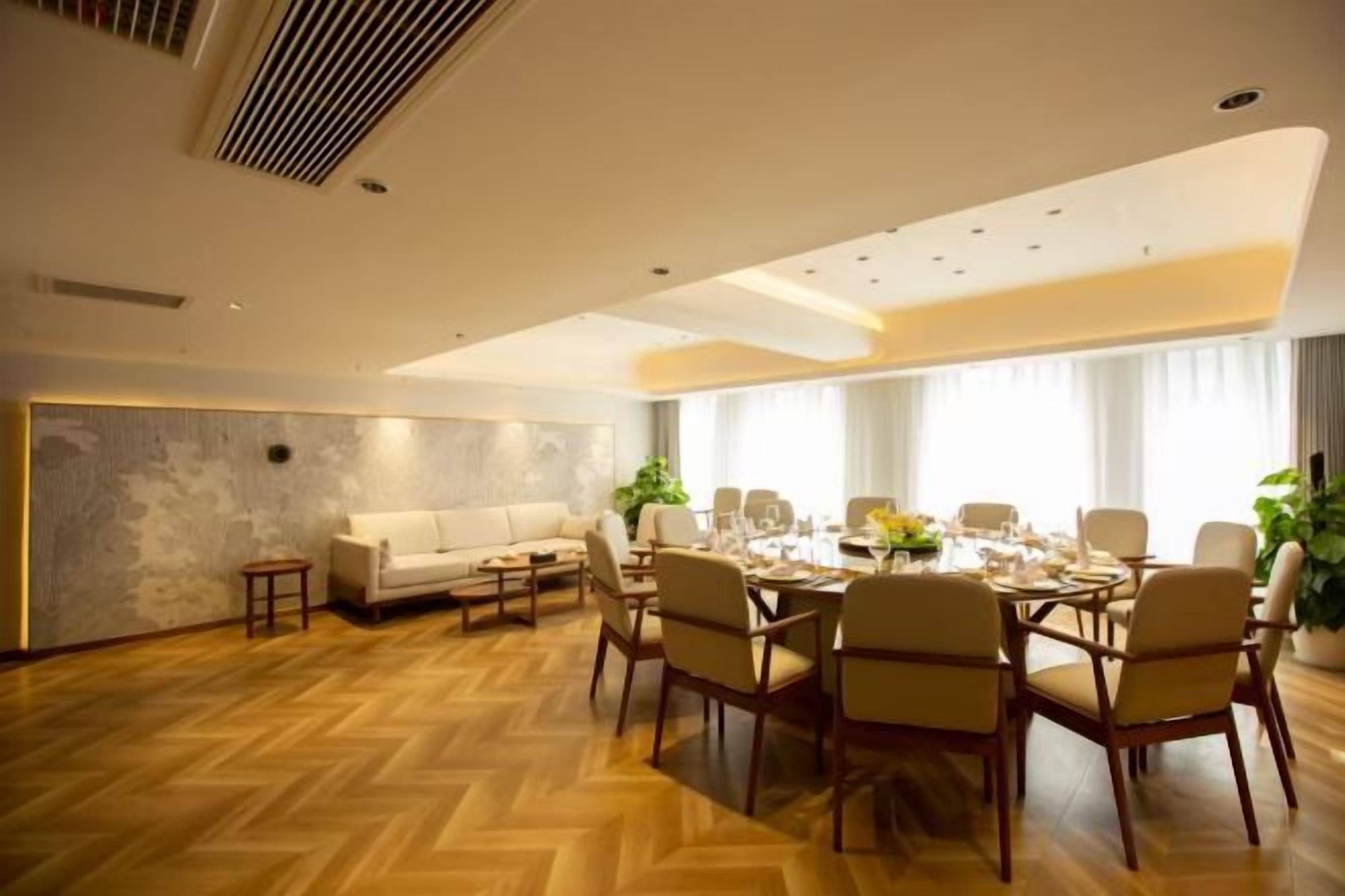 Uma sala de jantar com mesa redonda posta para seis pessoas, rodeada por seis cadeiras.
