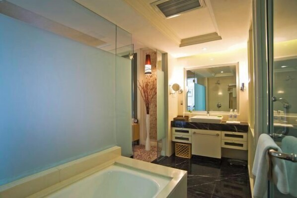 A modern bathroom with a large bathtub, a glass shower enclosure, and a vanity with a mirror. - Spring Downtown Hotel (Chengdu)