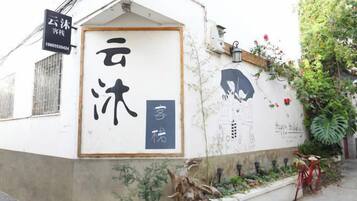 A building with a traditional Japanese architectural style, featuring a wooden door and a sign with Japanese characters.