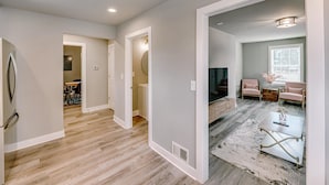 A spacious living area with a large coffee table, seating arrangement, and a view of the dining area. - Charming Voyage: Ypsi & AnnArbor (Ypsilanti)