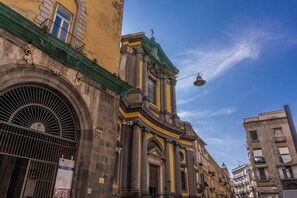 A historic building with classical architecture, featuring a prominent entrance and a green awning. - Timeless (Naples)