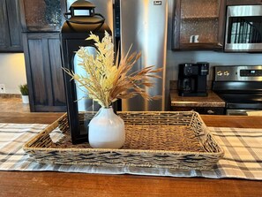A kitchen counter with a woven tray holding a vase of dried flowers and a black lantern. - Waterfront Property w/boat dockage-sleeps 18! (Huron)