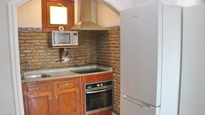 Una cocina compacta con microondas, horno y refrigerador.