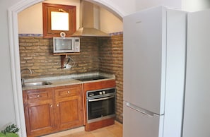 Una cocina compacta con microondas, horno y refrigerador.